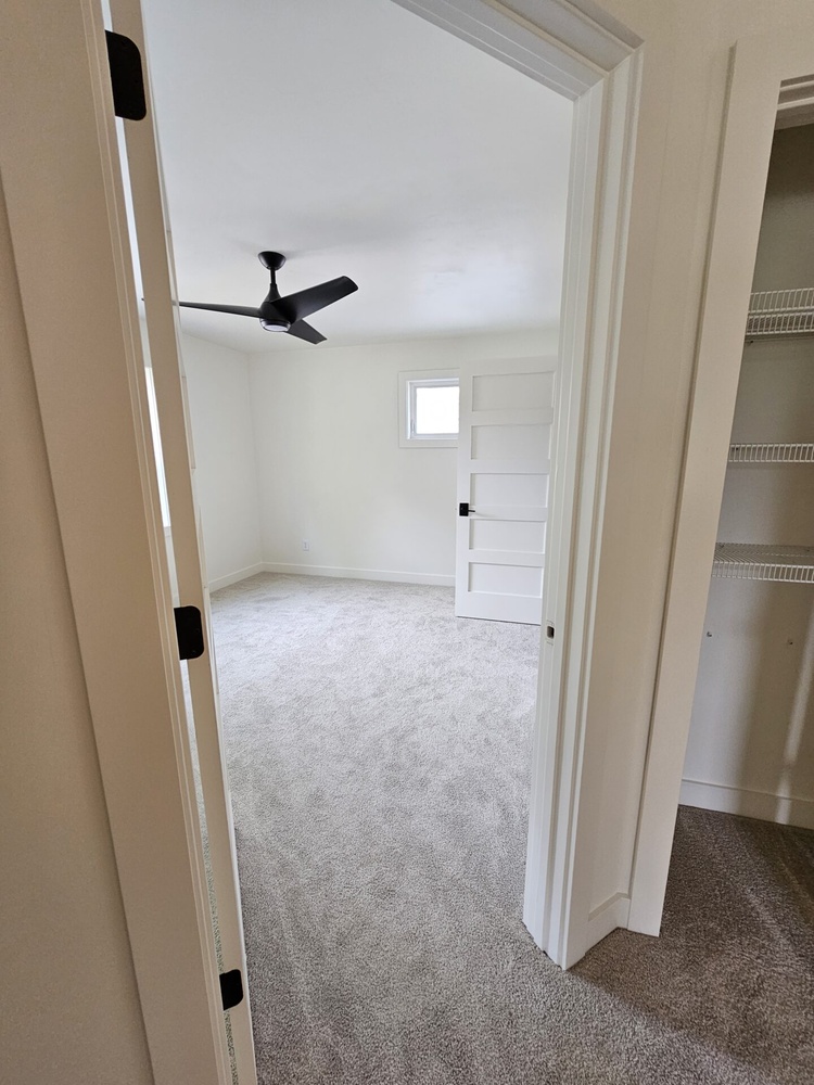 Bedroom with white walls and fan in new custom home by Midwest Design Homes in Kaukauna