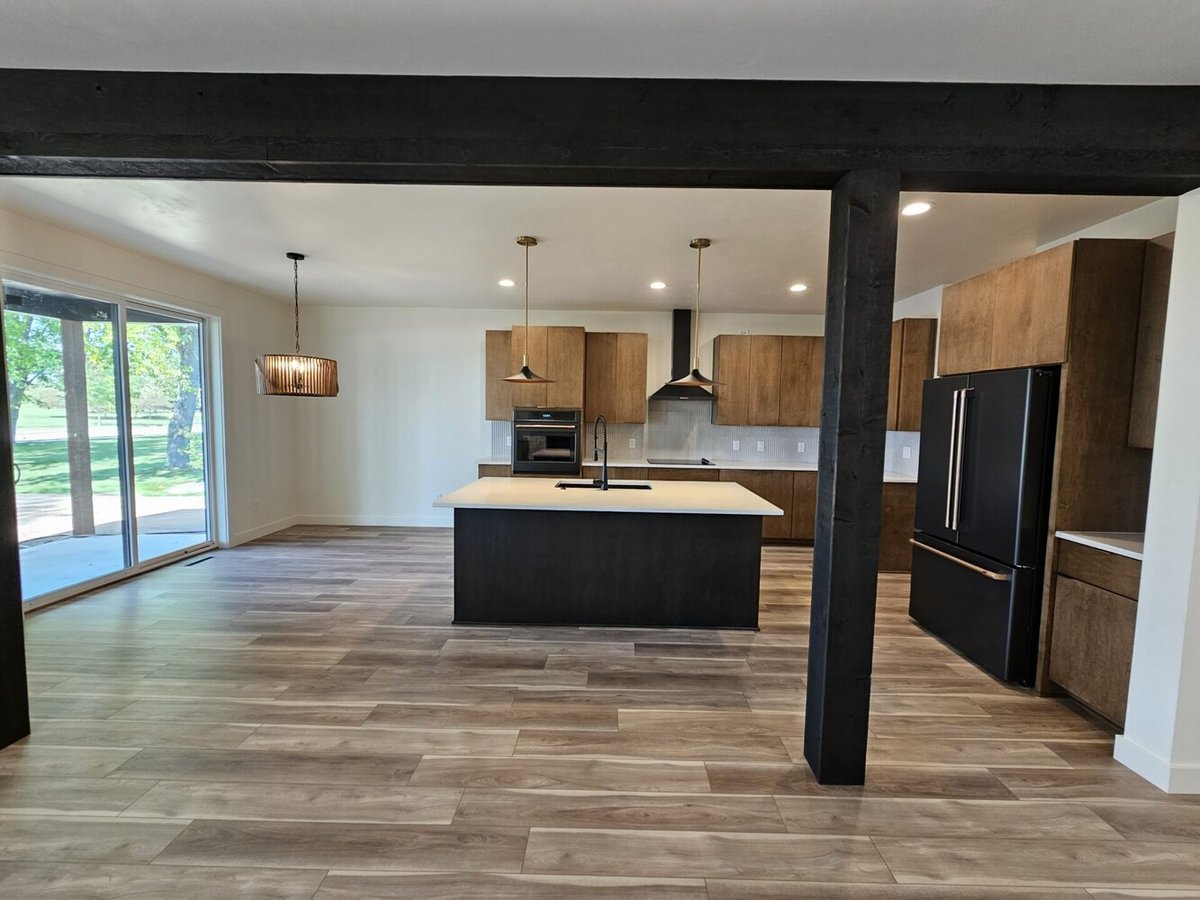 Bright modern kitchen with black island and wood cabinets by Midwest Design Homes in Kaukauna
