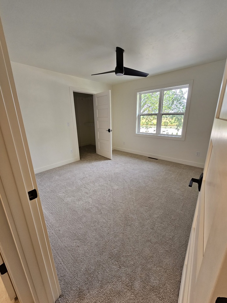 Custom home bedroom with large window and closet by Midwest Design Homes in Kaukauna, WI
