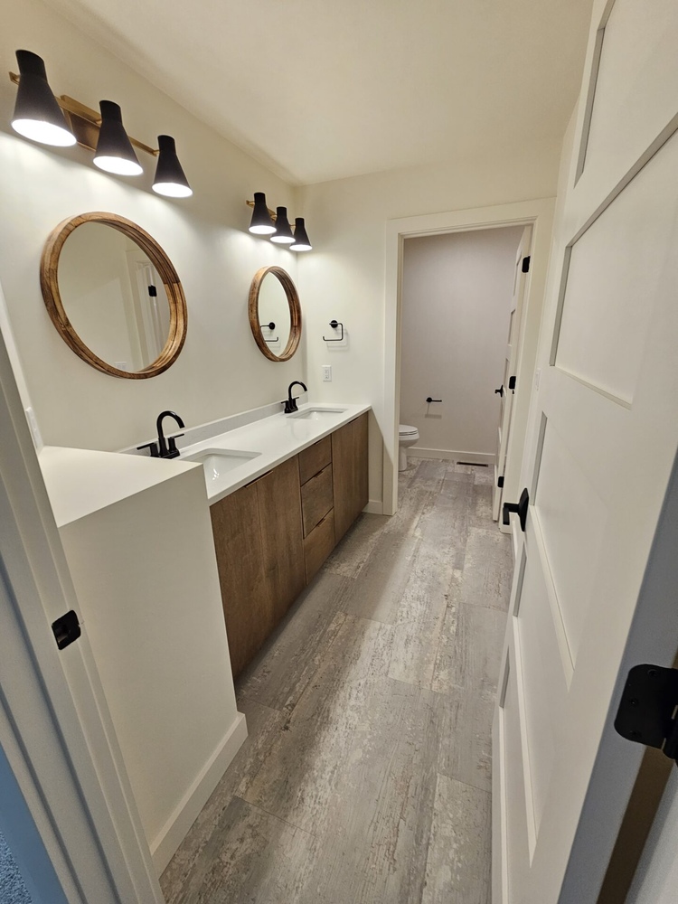 Double vanity bathroom with round mirrors by Midwest Design Homes in Kaukauna custom home