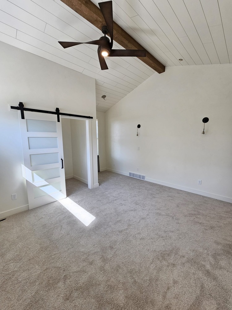 Master bedroom with vaulted shiplap ceiling in Kaukauna by Midwest Design Homes
