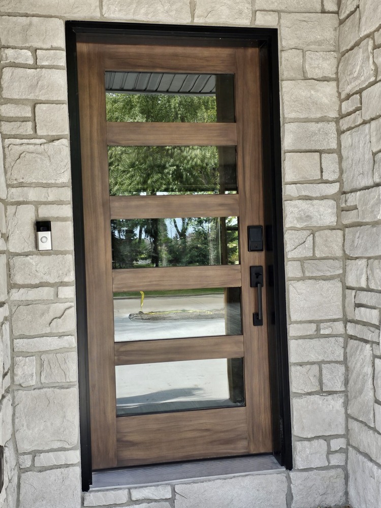 Modern wood and glass front door on custom home in Kaukauna by Midwest Design Homes