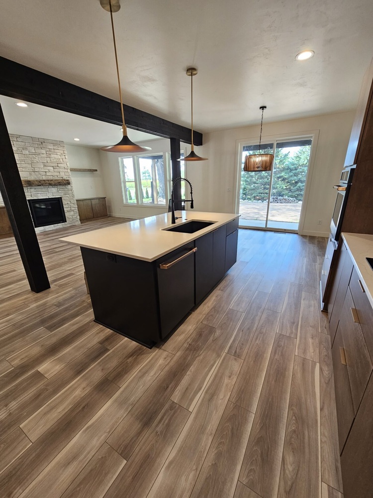 Open layout with kitchen island and dining area in Kaukauna home by Midwest Design Homes
