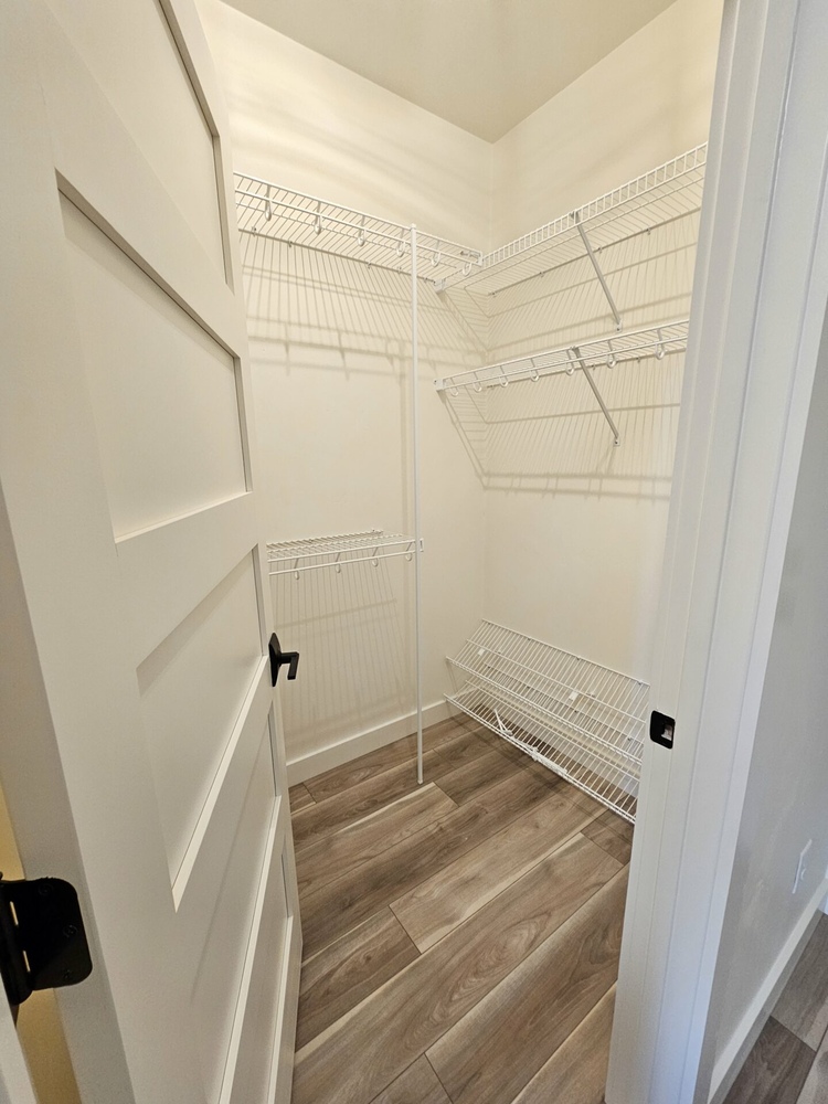 Small walk-in closet with white wire shelving in Kaukauna home by Midwest Design Homes