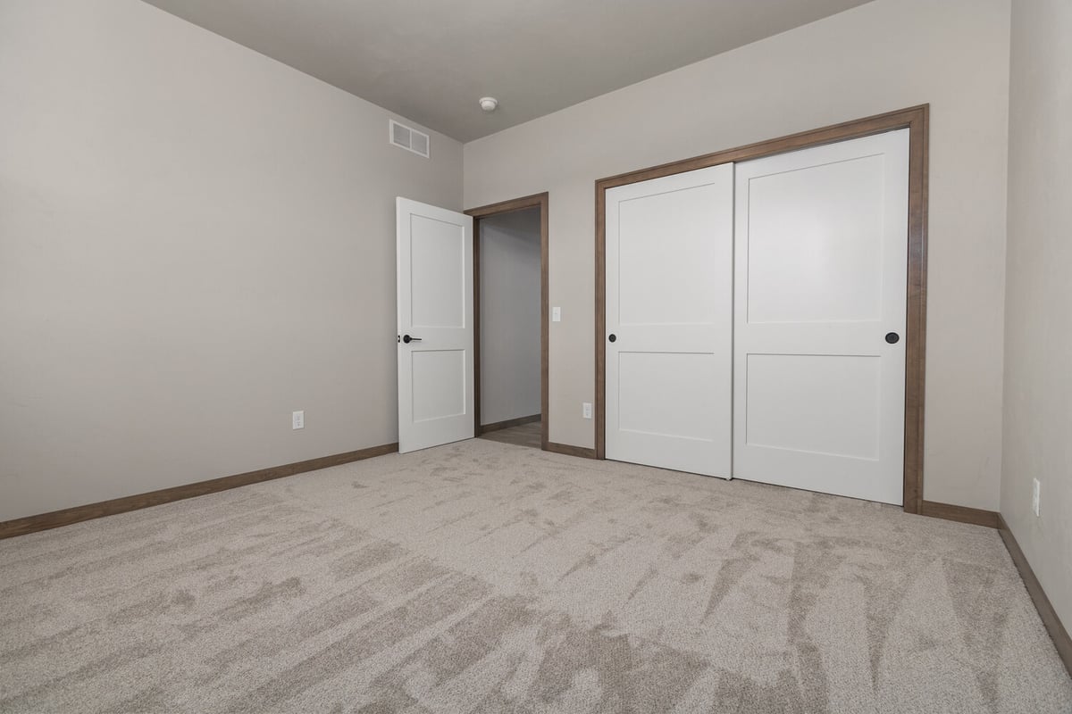 Custom-built bedroom with white closet doors by Midwest Design Homes in Green Bay, WI