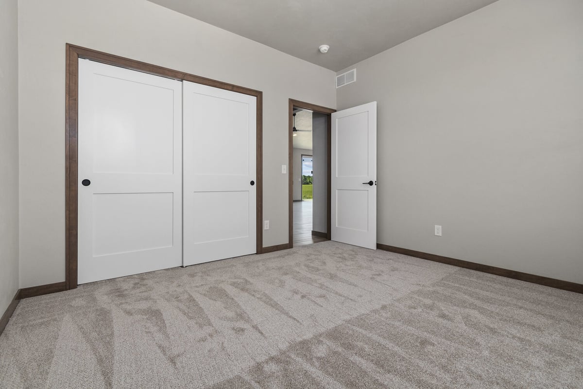 Empty bedroom with white closet doors in custom home by Midwest Design Homes in Neenah, WI
