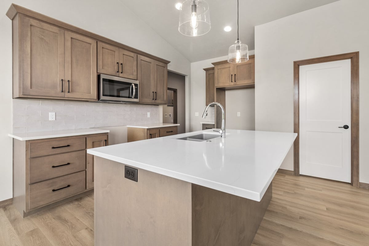 Modern kitchen with shaker cabinets and quartz island in Wisconsin home by Midwest Design Home