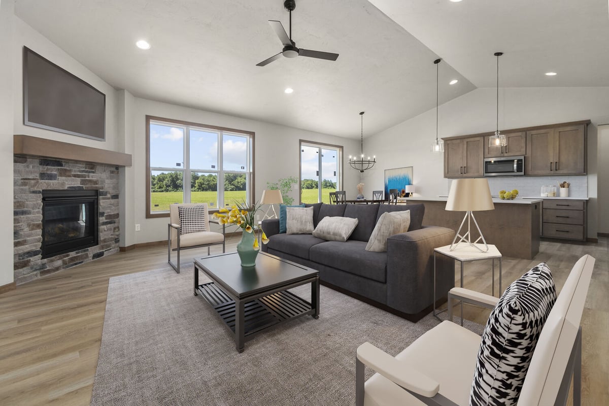 Staged living and dining space with kitchen island and large windows by Midwest Design Homes