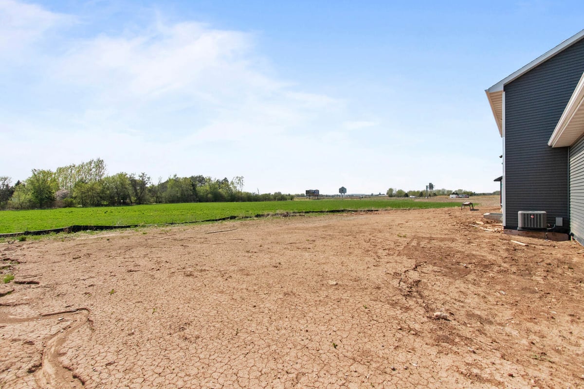 Side yard and open field beside new construction by Midwest Design Homes in Wisconsin