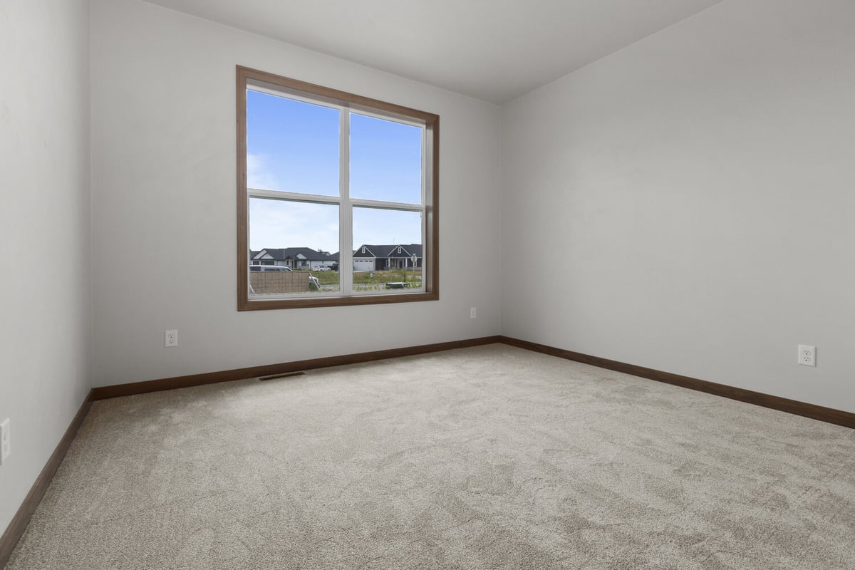 Bedroom with large window in Appleton WI custom home by Midwest Design Homes