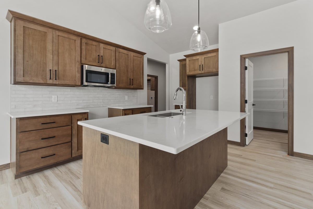 Spacious kitchen design with island and pantry in Kaukauna WI by Midwest Design Homes