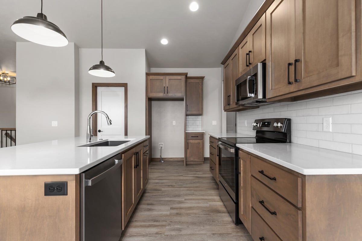 Custom kitchen with quartz counters and wood cabinetry by Midwest Design Homes in Greenville, WI