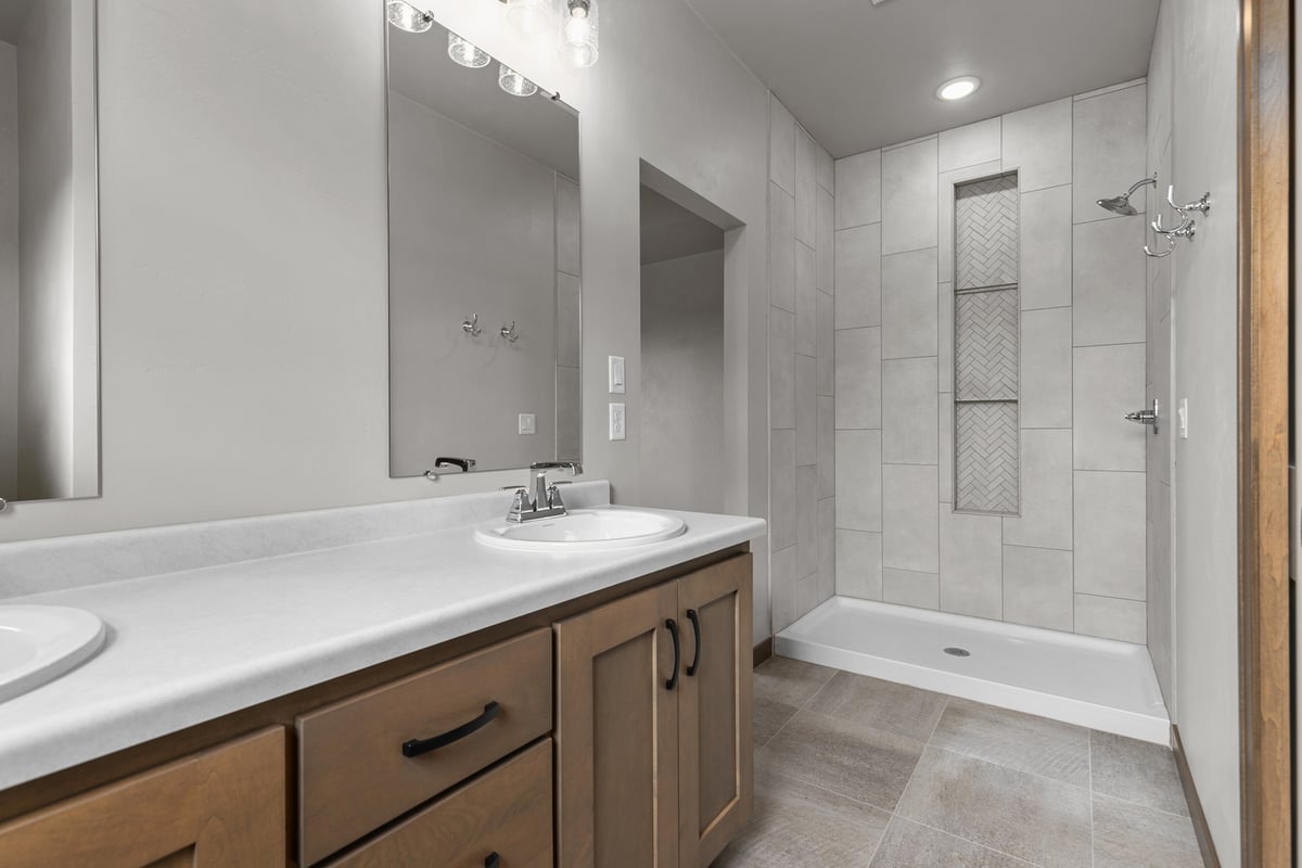 Double sink vanity and tiled shower in Kaukauna, WI custom home by Midwest Design Homes