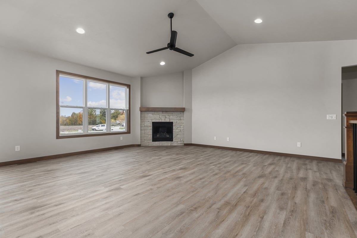 Large living room with vaulted ceiling and fireplace in a Midwest Design Homes custom home