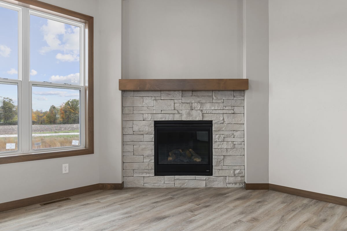 Living room stone fireplace design in a new home by Midwest Design Homes in Bellevue, WI