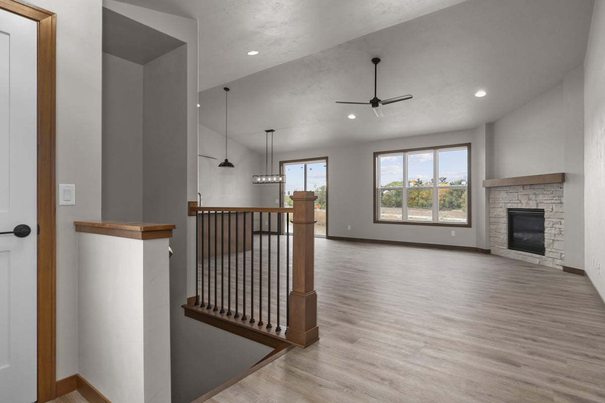 Open living area with stone fireplace in a custom home by Midwest Design Homes in Ledgeview, WI