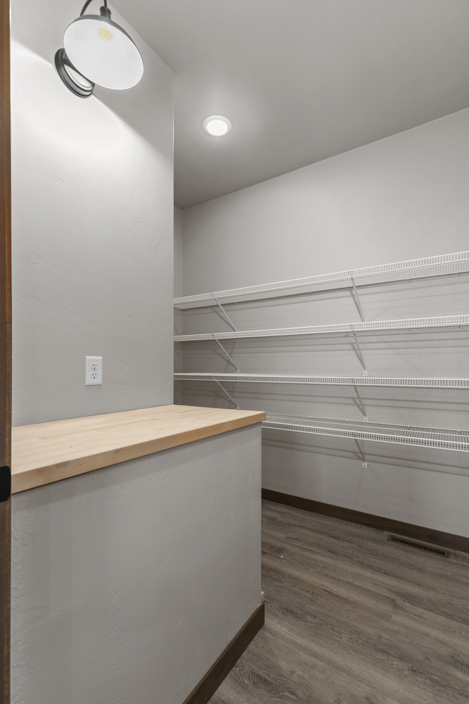 Pantry with counter and open shelves in a new custom build by Midwest Design Homes in Ellington