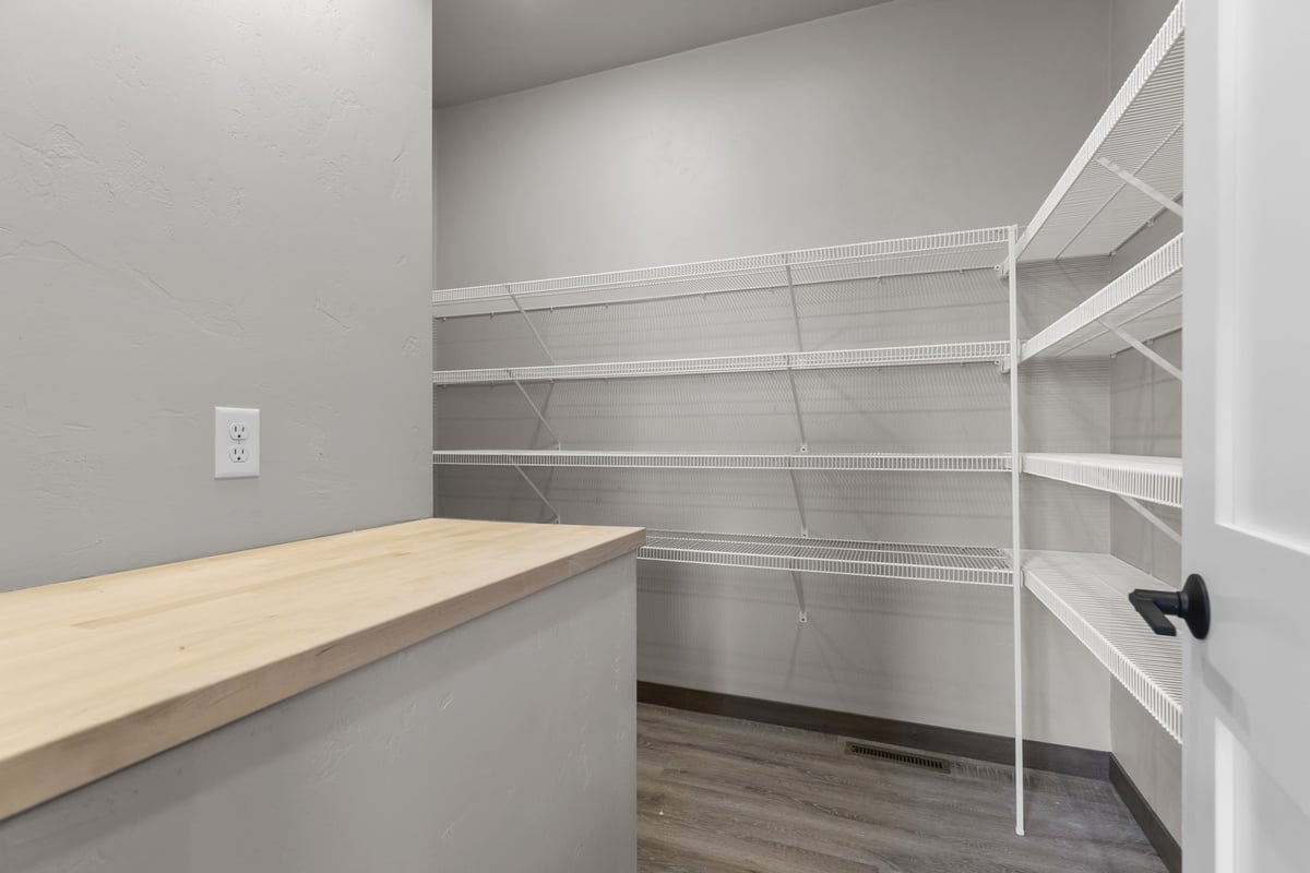 Spacious pantry design with workspace in a custom home by Midwest Design Homes in Ledgeview
