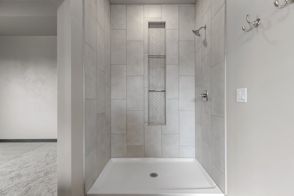 Tiled walk-in shower with niche in custom home by Midwest Design Homes in Kaukauna, Wisconsin