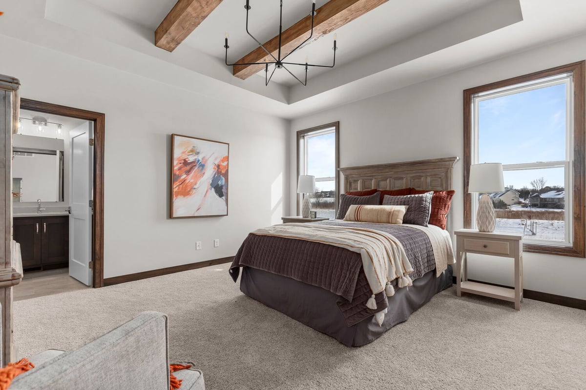 Bright custom bedroom with wood bed frame by Midwest Design Homes in Neenah, WI