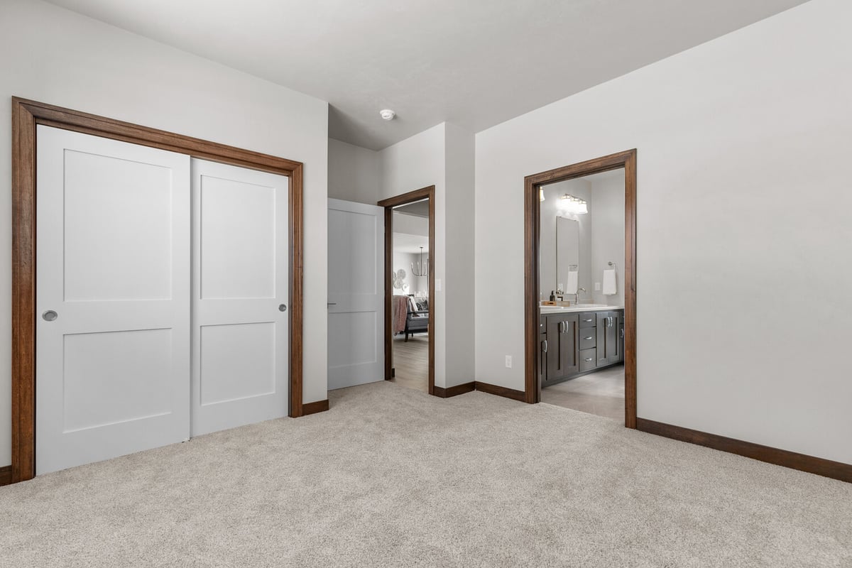 Carpeted bedroom with bath access in custom Kaukauna home by Midwest Design Homes