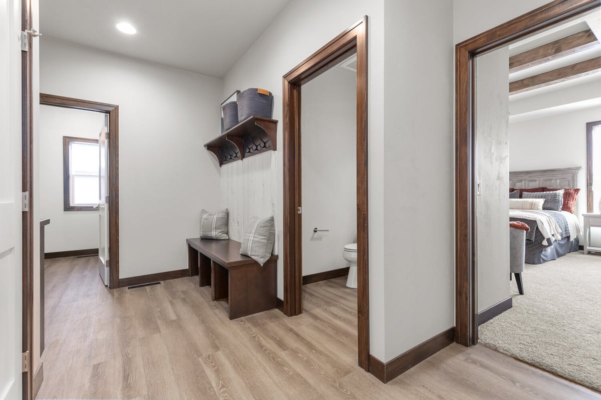 Custom hallway with wood floors and bench by Midwest Design Homes in Lawrence, WI