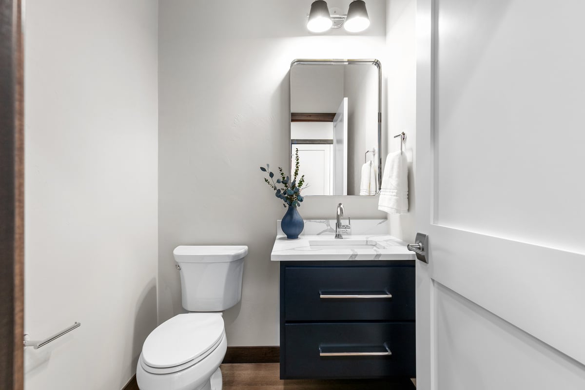 Elegant custom powder room with navy vanity by Midwest Design Homes in Harrison, WI