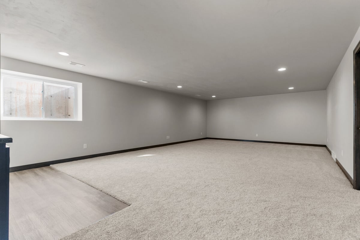 Expansive carpeted basement with window light in Kaukauna home by Midwest Design Homes