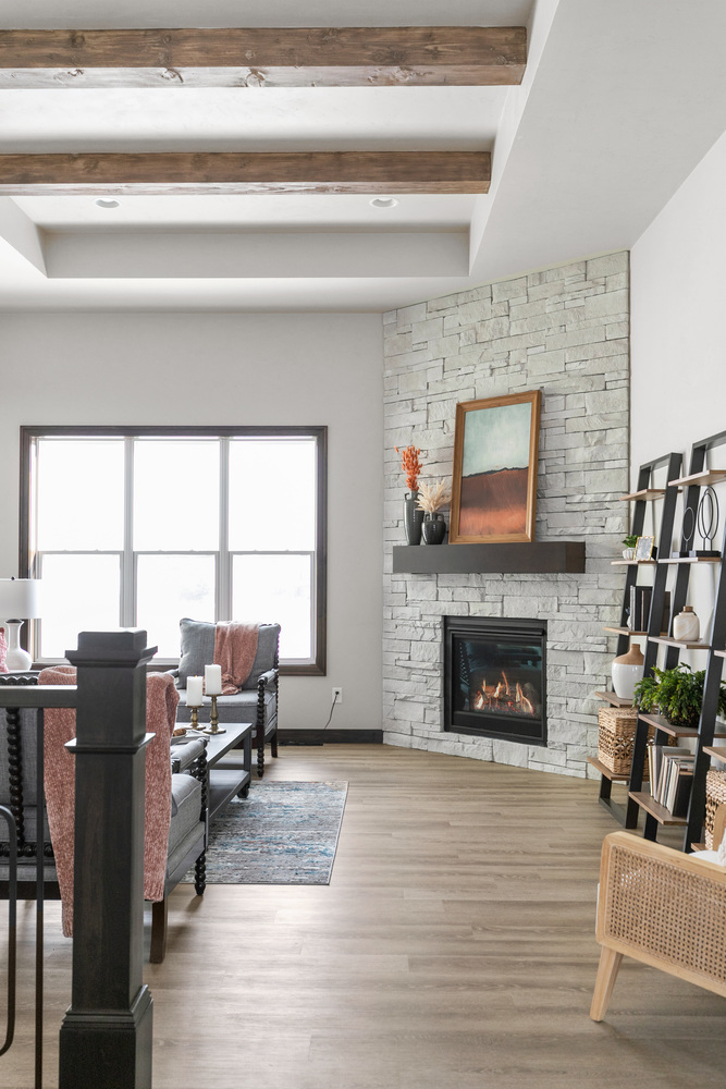 Living room with fireplace and ceiling beams by Midwest Design Homes in Kaukauna, WI