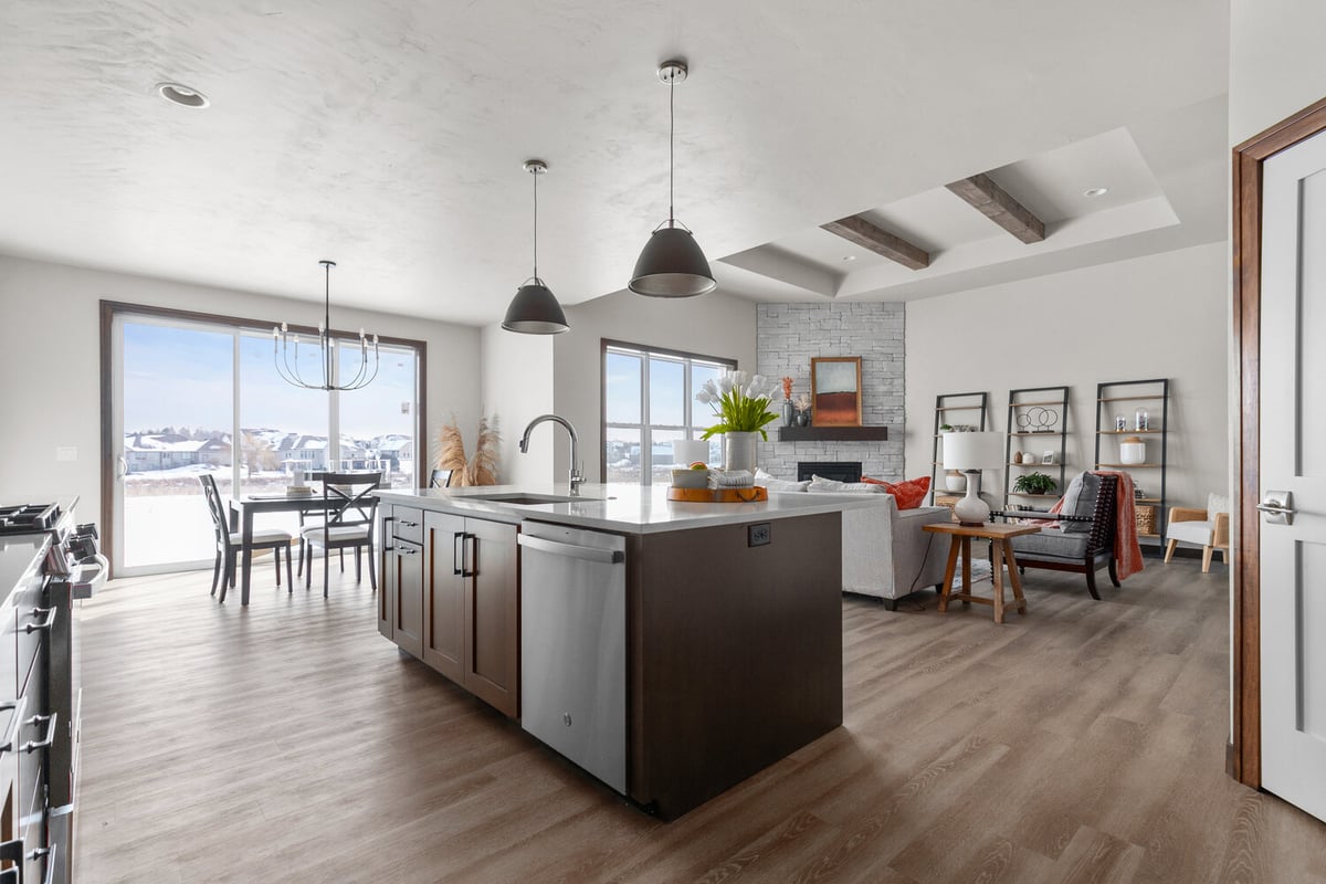 Open-concept kitchen with island and fireplace by Midwest Design Homes in Bellevue, WI