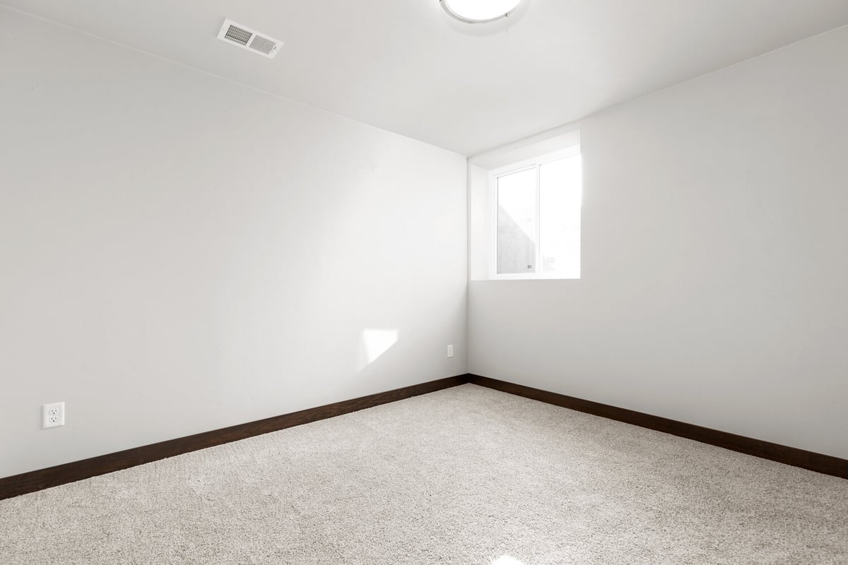 Simple white bedroom in Midwest Design Homes custom home in Kaukauna, WI with carpet