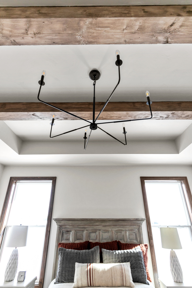 Symmetrical bedroom windows with wood beam ceiling in Kaukauna home by Midwest Design Homes