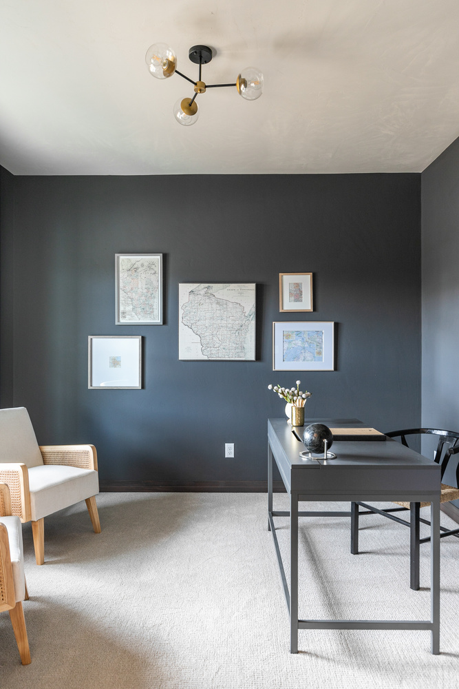 Custom home office in Appleton, WI with dark walls and framed maps by Midwest Design Homes