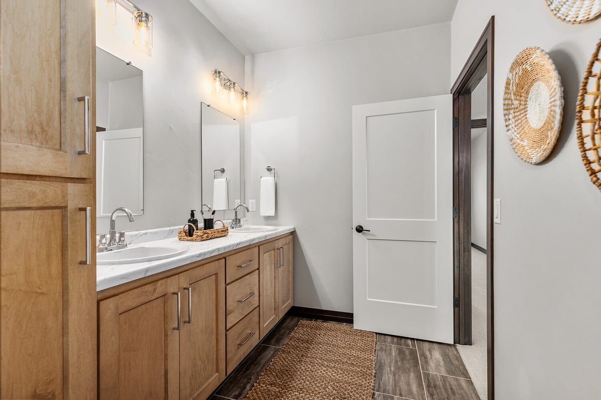 Double vanity bathroom with wood cabinetry in Wisconsin custom home by Midwest Design Homes