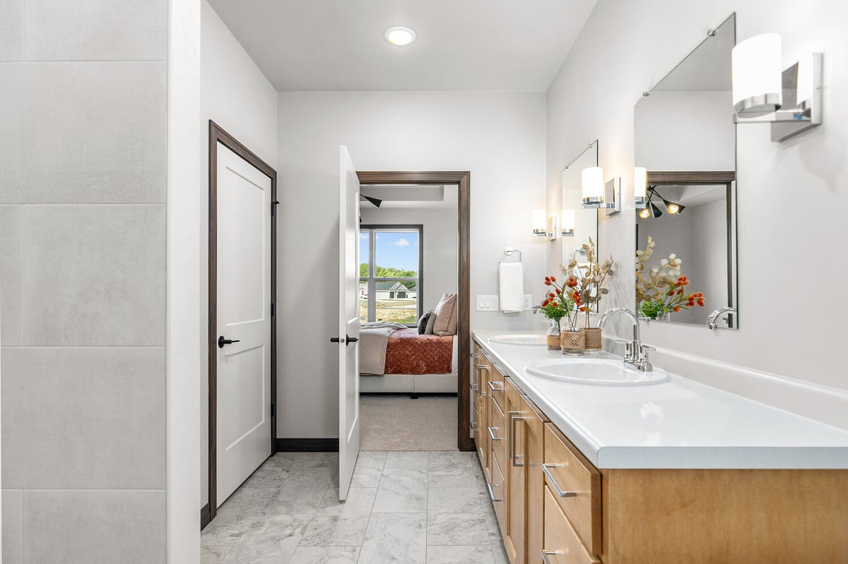 Ensuite bathroom with view into bedroom in custom home by Midwest Design Homes