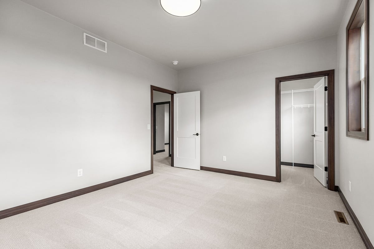 Finished bedroom with door to closet and hallway in Wisconsin home by Midwest Design Homes