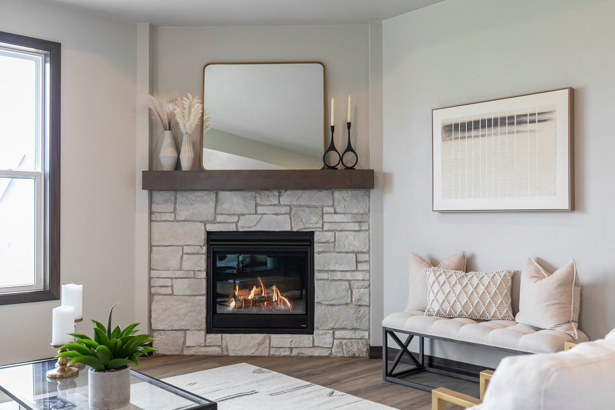 Fireplace with stone surround and seating in De Pere, WI custom home by Midwest Design Homes