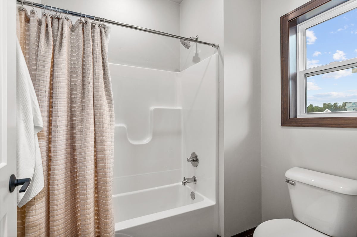 Full bathroom with tub and window in custom Wisconsin home by Midwest Design Homes