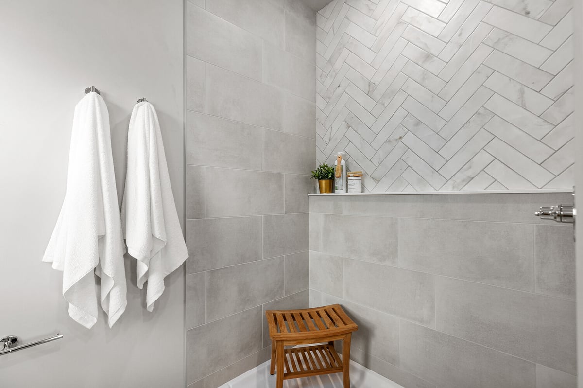 Gray tile shower with bench and shelf in Wisconsin custom home by Midwest Design Homes