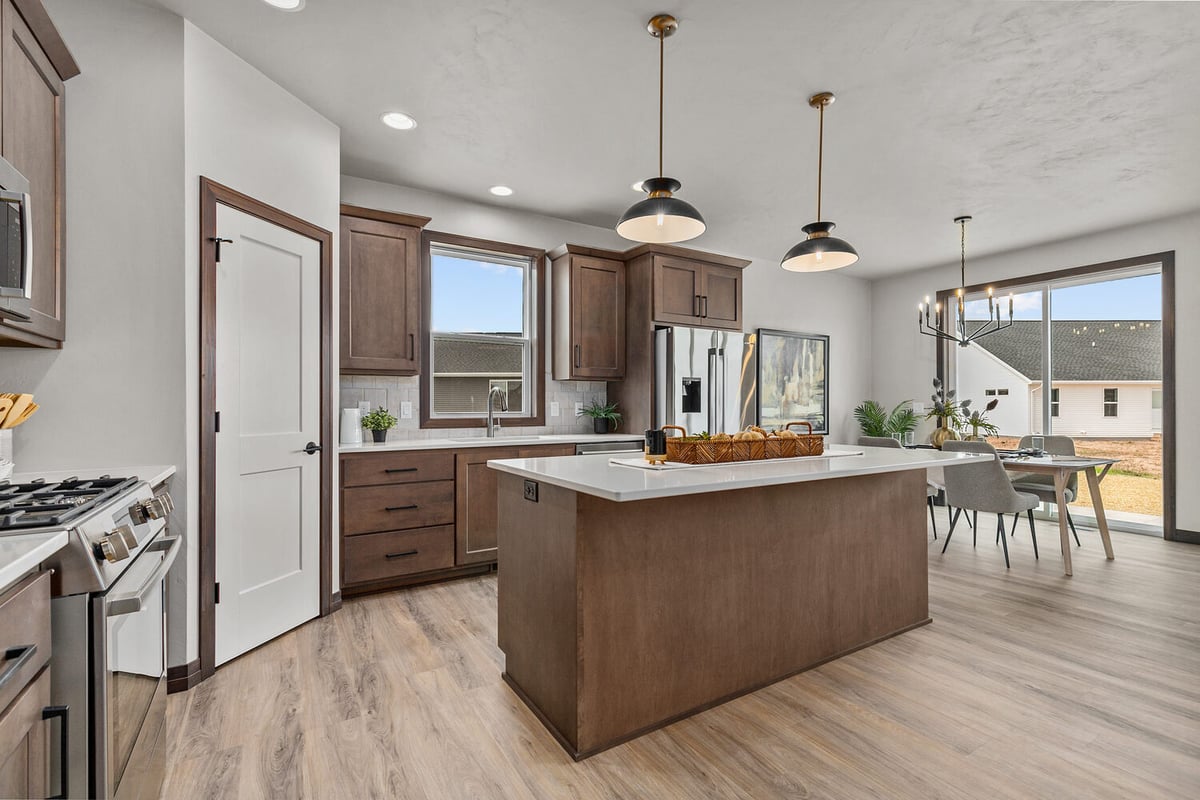 Open-concept kitchen and dining layout in De Pere, WI by Midwest Design Homes