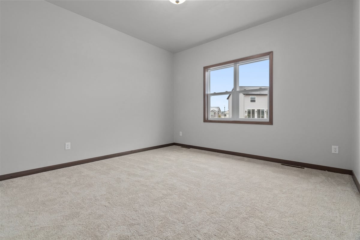 Bright bedroom with large window in custom home by Midwest Design Homes, Harrison WI