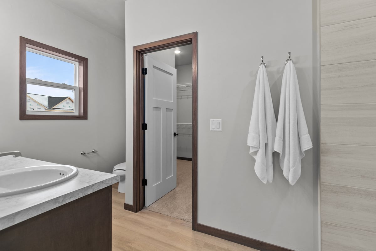 Custom home bathroom in Kaukauna, WI featuring a white toilet and dual towel hooks