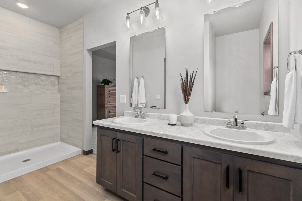 Custom home bathroom in Kaukauna, WI with dual sinks and dark wood vanity by Midwest Design