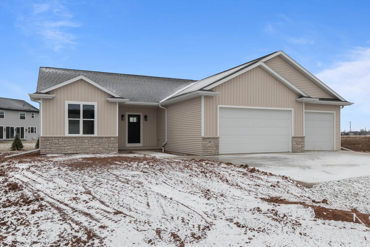 De Pere, WI custom home exterior by Midwest Design Homes with stonework and siding