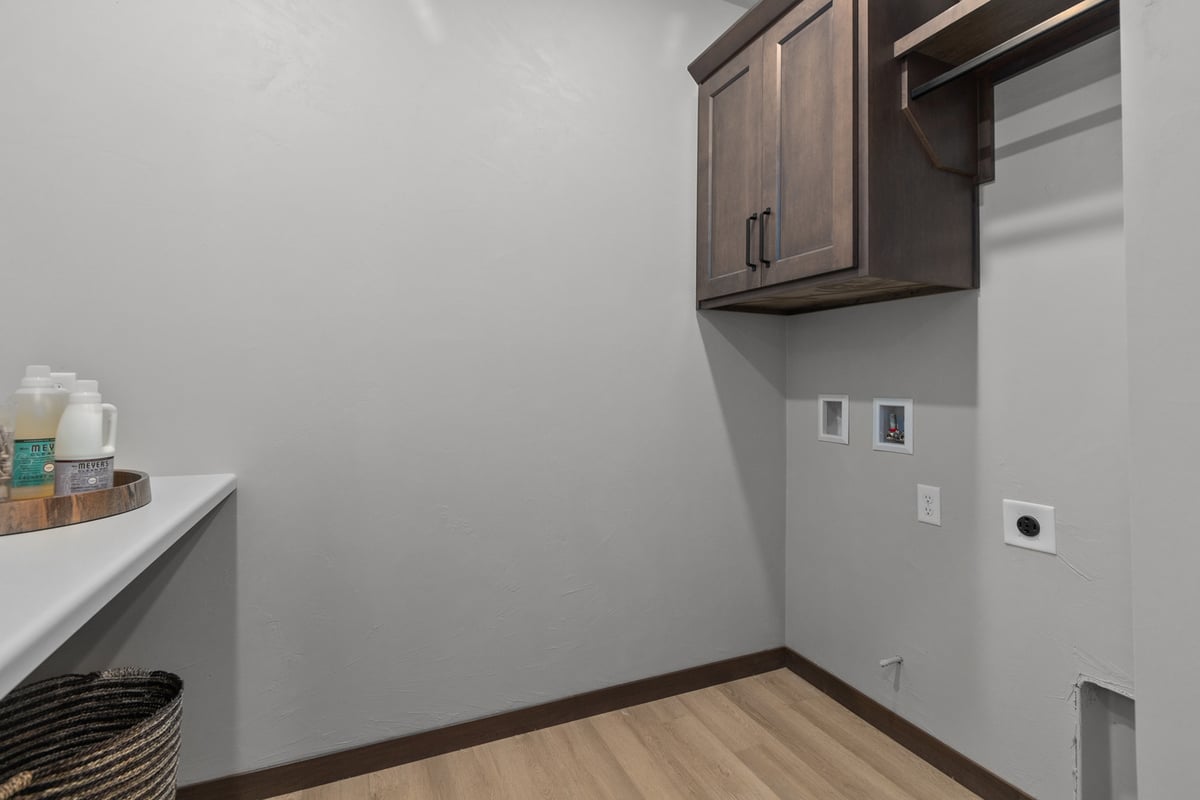 Laundry room with cabinets and hookups in a custom home by Midwest Design Homes, WI