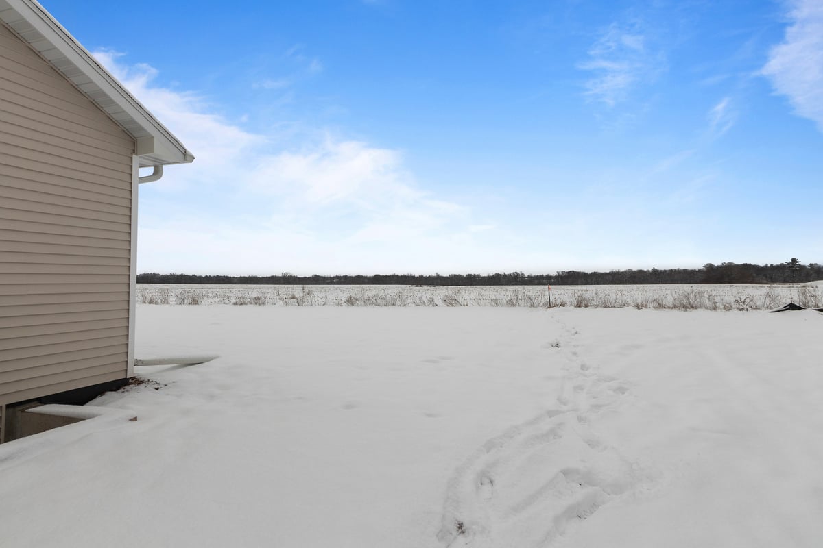 Backyard snow-covered field view behind custom home by Midwest Design Homes in Kaukauna, WI