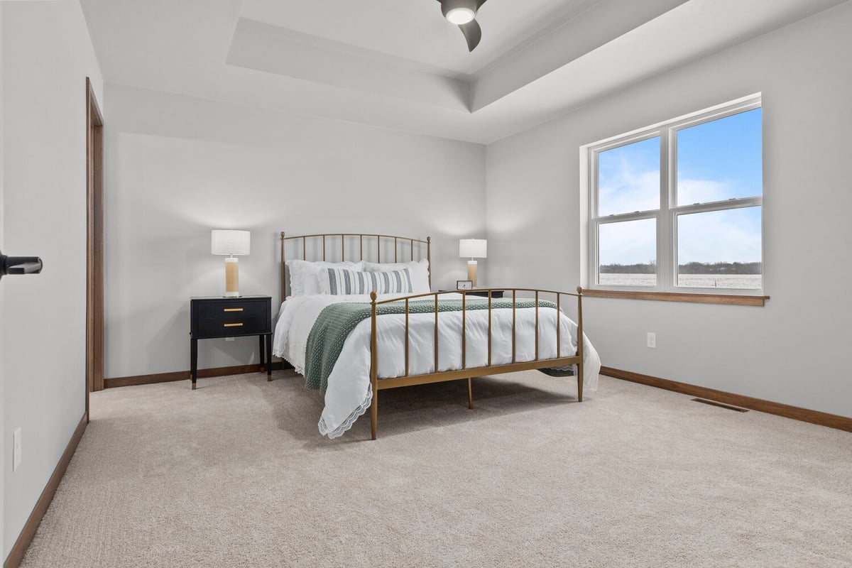 Bright master bedroom with tray ceiling in custom Kaukauna, WI home by Midwest Design Homes