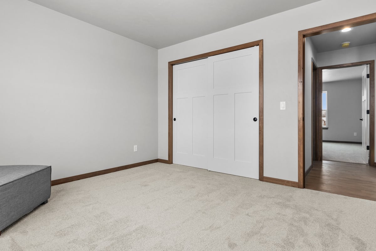 Carpeted bedroom with wood trim by Midwest Design Homes in Kaukauna, WI custom home