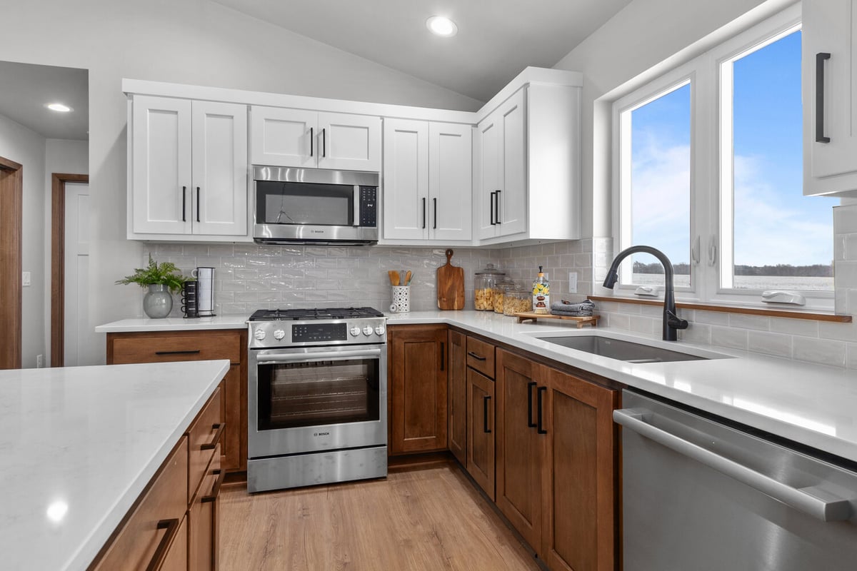 Custom kitchen with dual-tone cabinetry and tile backsplash in Kaukauna, WI by Midwest Design Homes