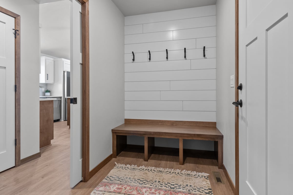 Mudroom with wood bench and coat hooks in Kaukauna, WI home by Midwest Design Homes